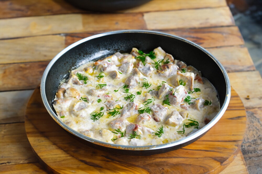 Pork in Sour Cream Sauce with Mushrooms in a Skillet