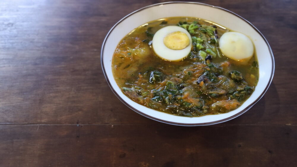 Spring Meatless Nettle and Sorrel Soup Cooked in a Cauldron over a Campfire